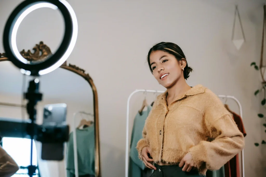 A fashion influencer filming a video with a ring light and smartphone, managed by a social media ad agency in Bangalore.