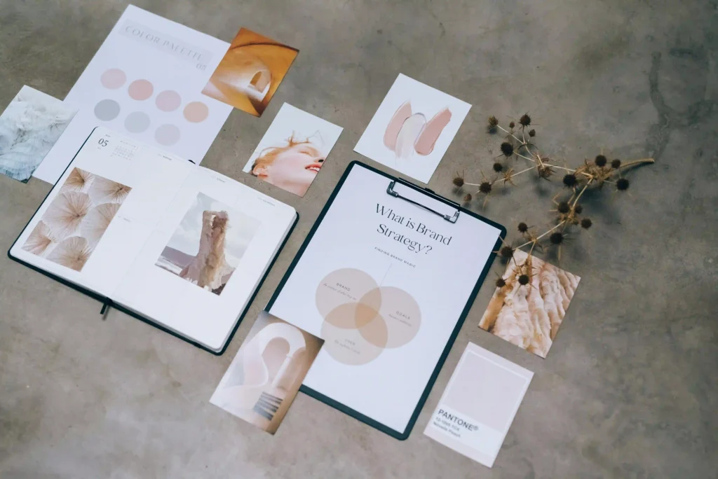 "Brand Strategy",an open planner with fashion photography, a "Color Palette" card with soft pastel swatches, and a Pantone chip. conveying a professional design process by a branding agency in Bangalore
