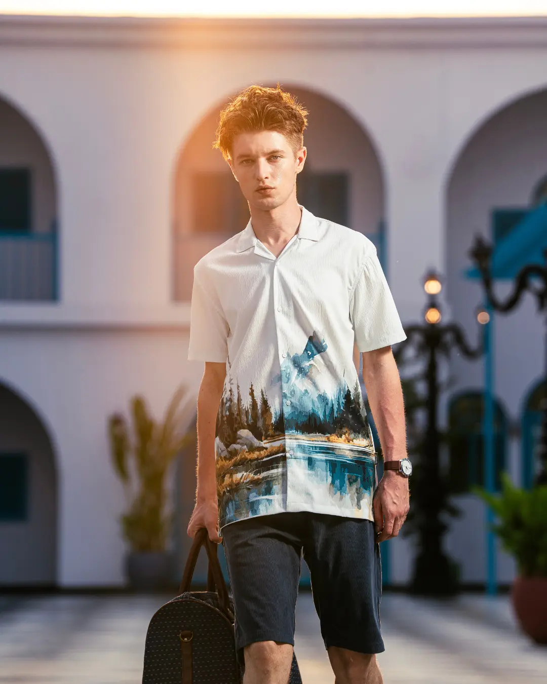A young man walks outdoors during golden hour, styled by a fashion stylist in Bangalore.